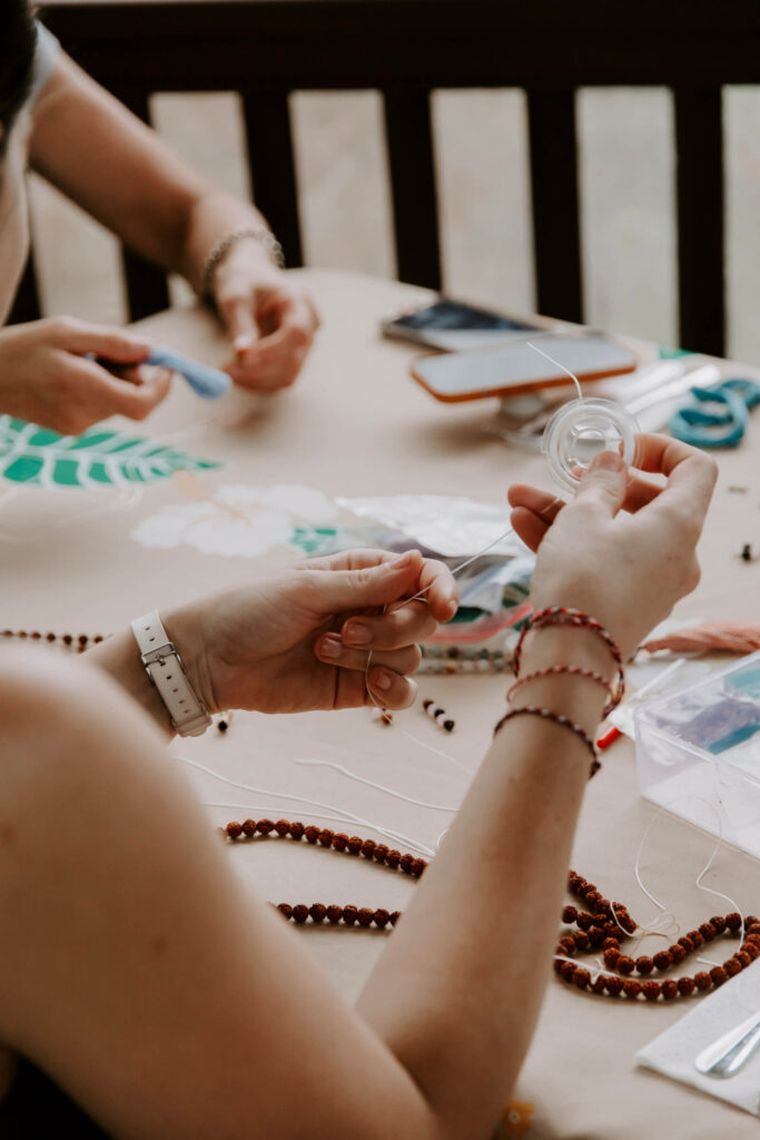 Making a mala bead necklace during training for becoming a certified yoga instructor