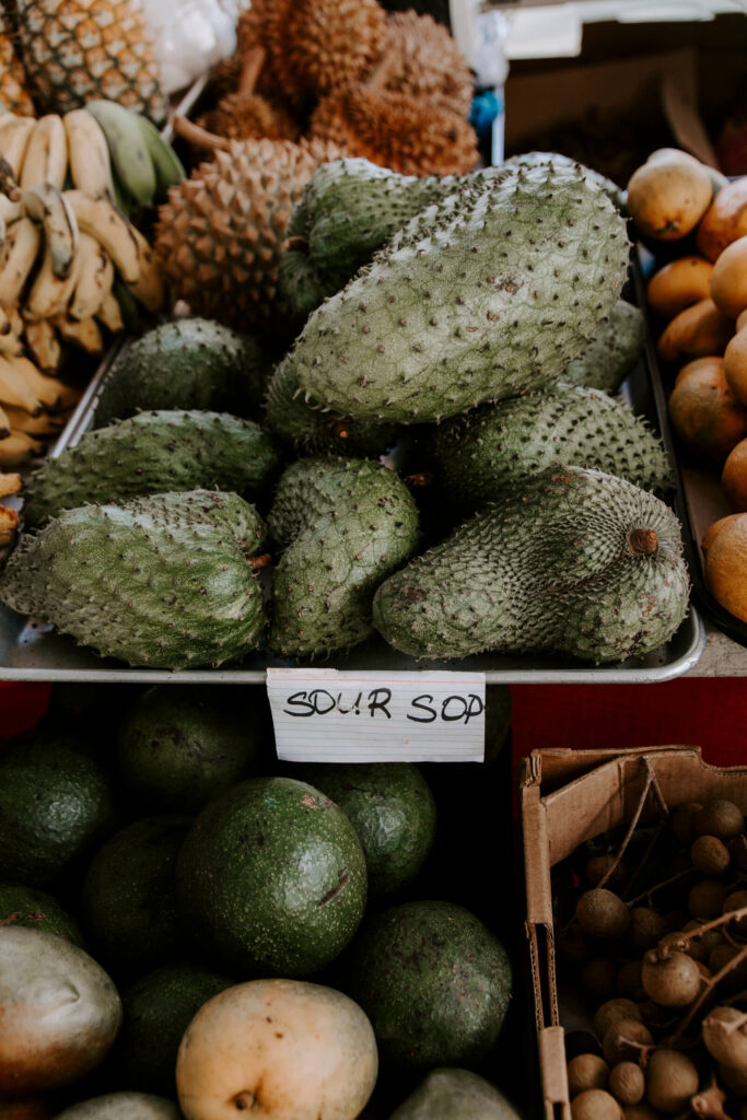 Soursop fruit sitting in a tray at a Hawaiian farmers market