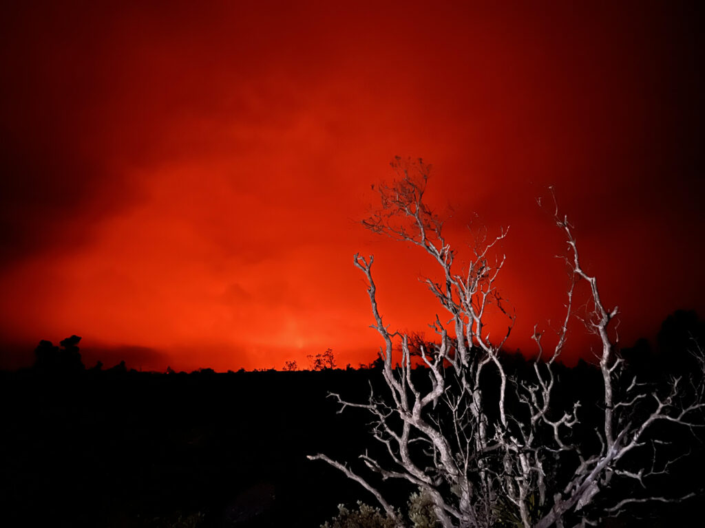 A red sky with a dark landscape outlined in the foregorund