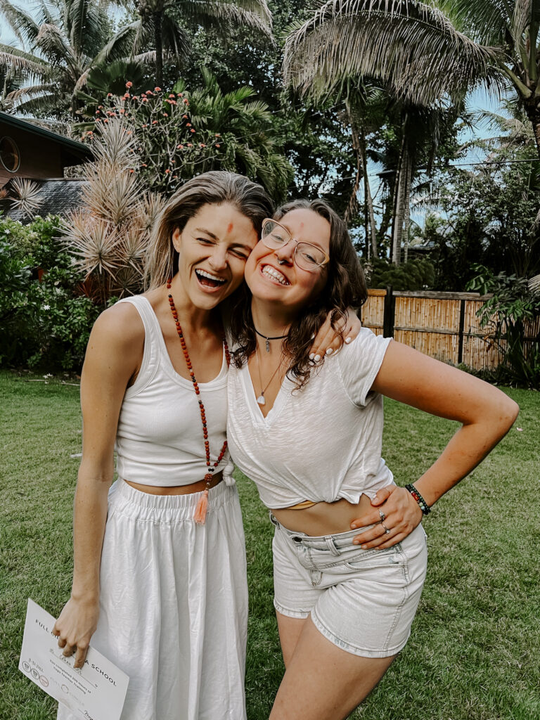 Two girls hugging and laughing after becoming a certified yoga instructor