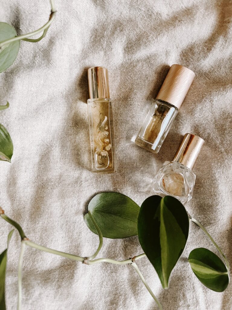 Three clear glass essential oil bottles laid out on tan fabric